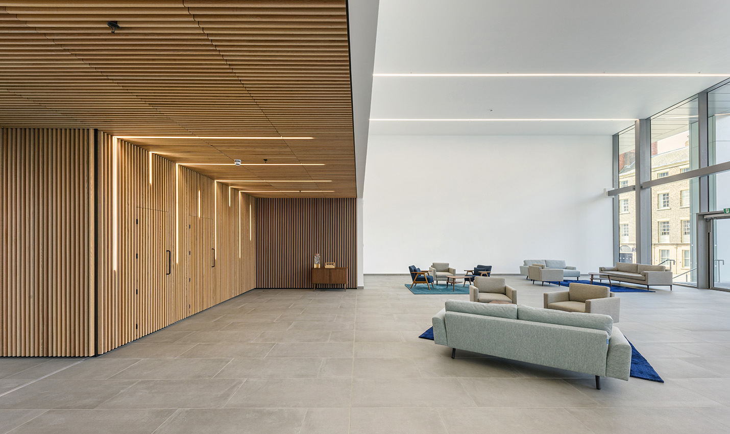 A interior view of a wooden fitted kitchen with island area, feature lighting and furniture