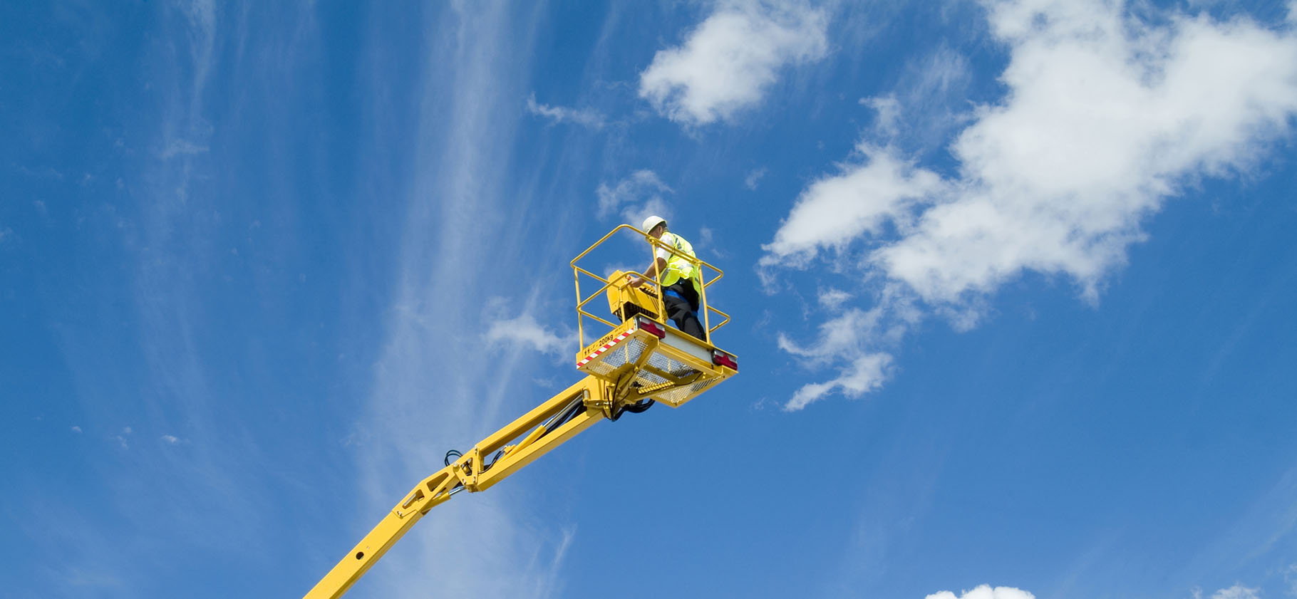 View of a access platform extended into the sky with clouds and operator