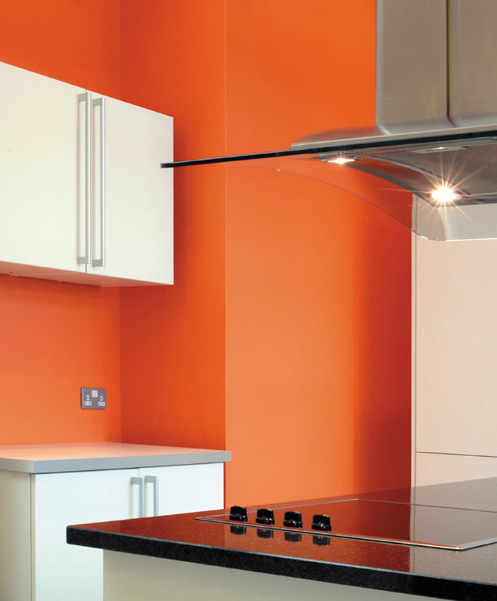 Residential kitchen detail looking past a hob to orange wall