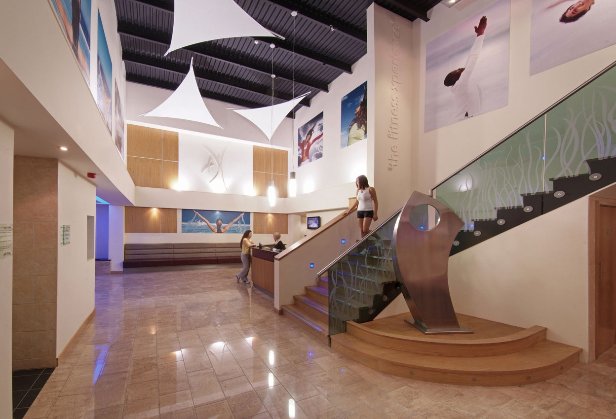Interior of a leisure club reception area with staircase and sculpture