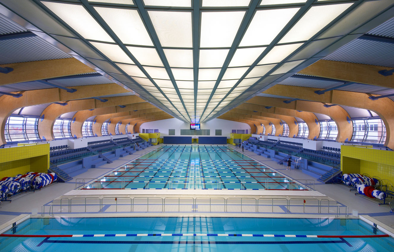 A wide view of aquatic centre swimming pools with wooden beamed ceiling 