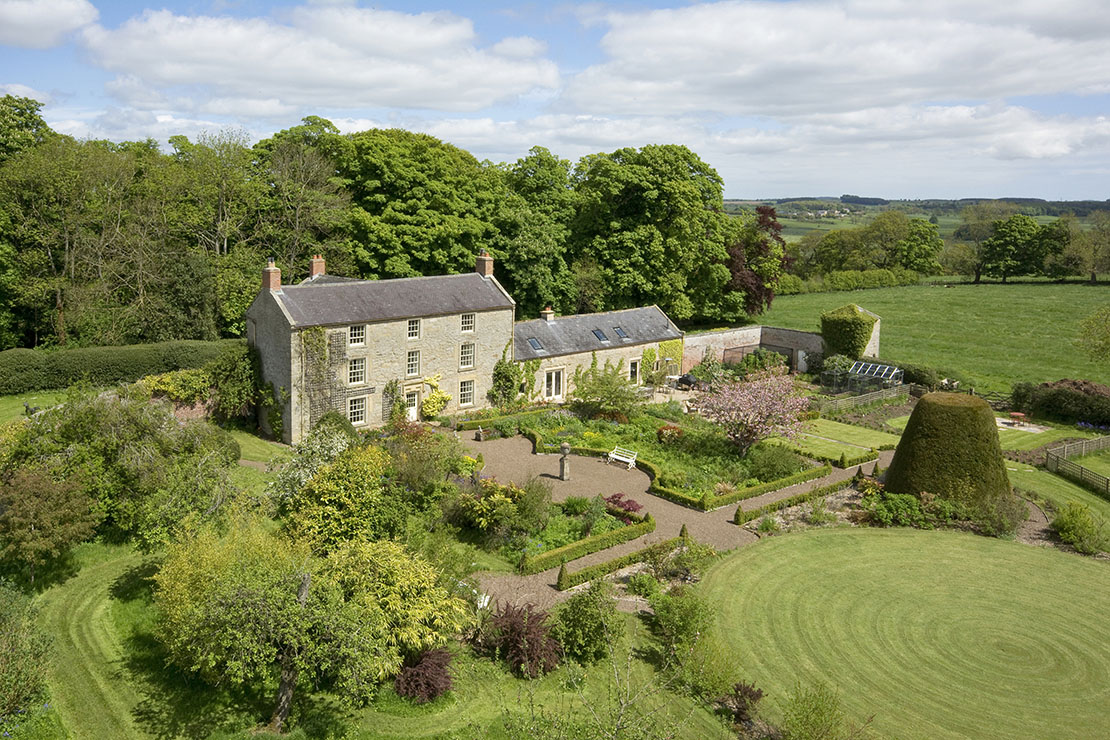 Residential countryside property exterior with gardens in summer