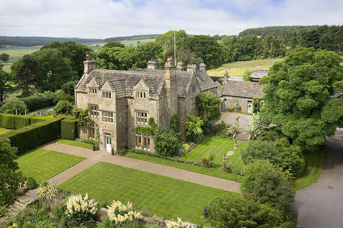 Exterior of a period property in summer with gardens and landscaping