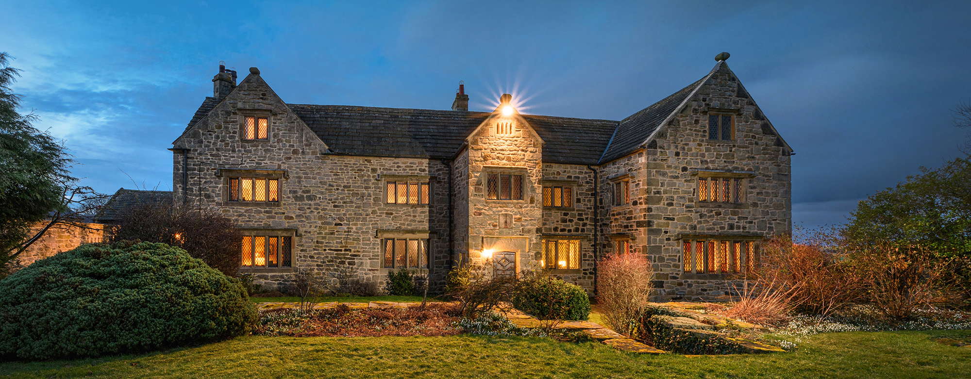 Architectural elevation of a period property illuminated at dusk with blue sky