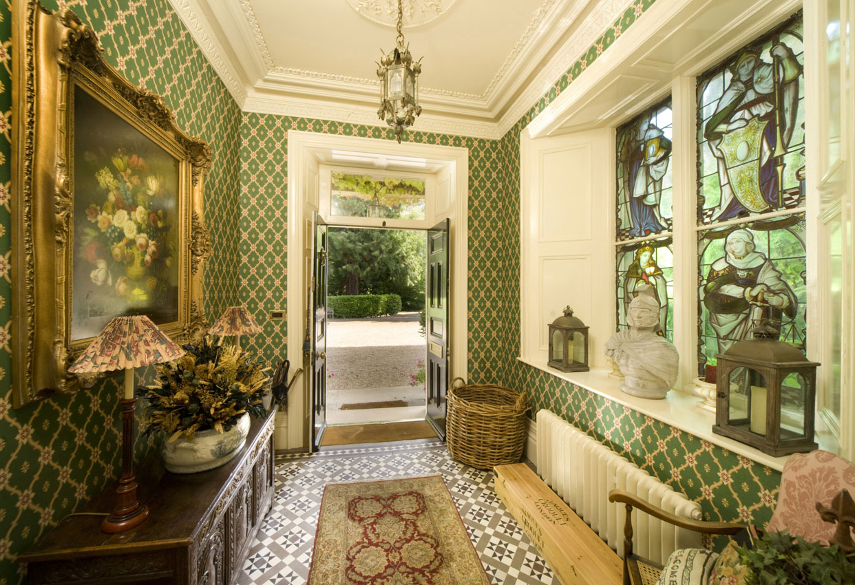 Entrance area to a residential period property with stained glass window and tiled floor