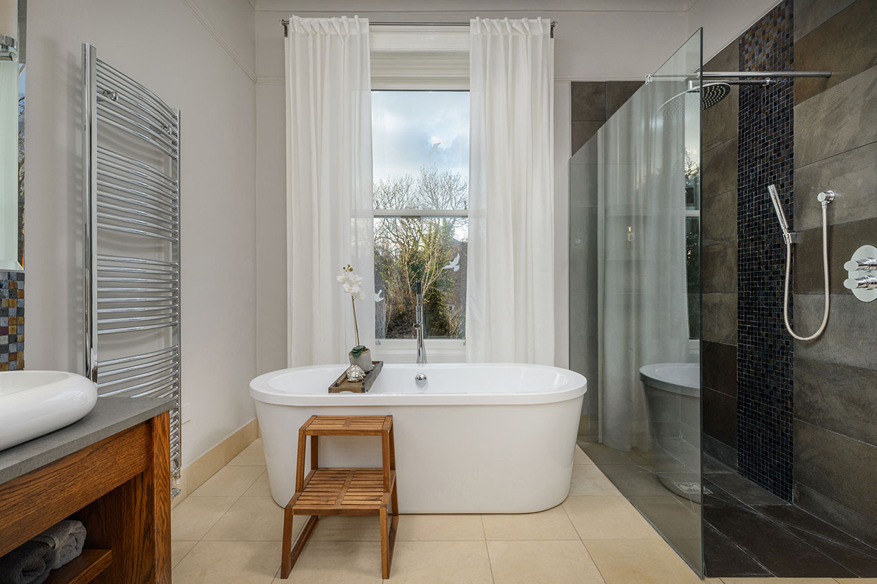 Bathroom interior with shower and roll top bath