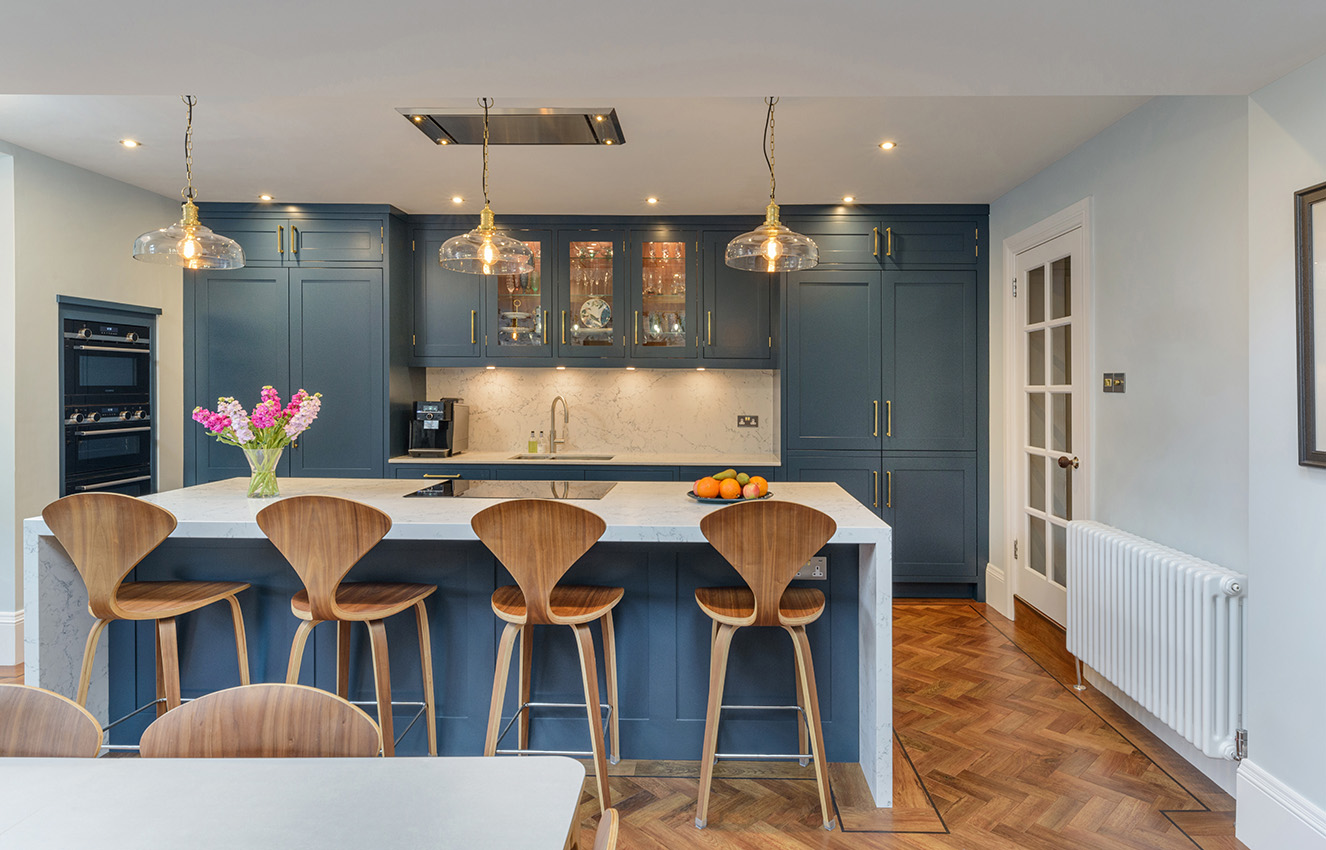 Interior of a kitchen with stools and pendent lighting